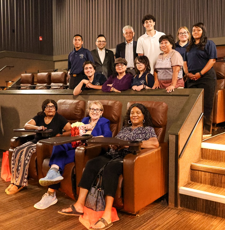 Senator Reyes sits in a movie theater with event attendees, volunteers, and partners