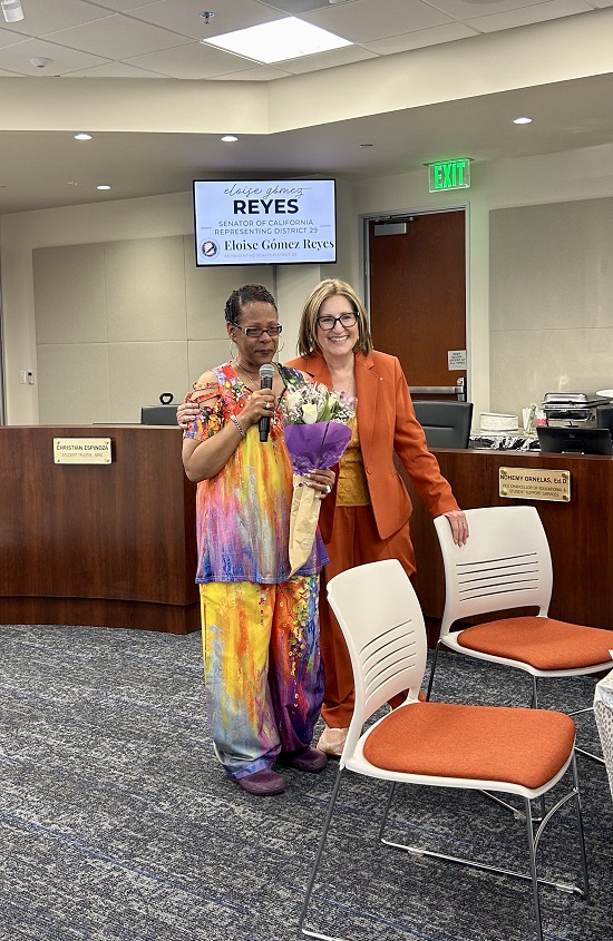 Senator Reyes accepts flowers from attendee